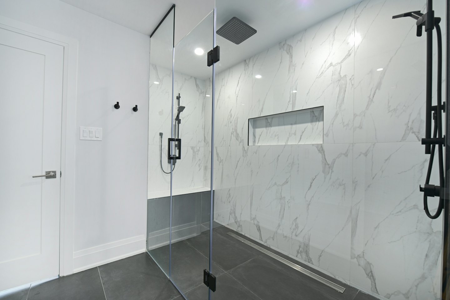 Salle de bain moderne avec douche carrelée de marbre.